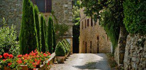A stone building with flowers on the side of it.