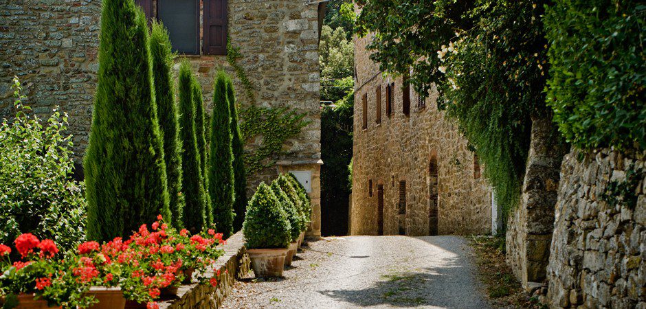 A stone building with flowers on the side of it.