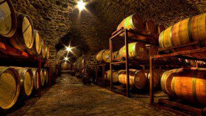 A wine cellar with many barrels of wine.