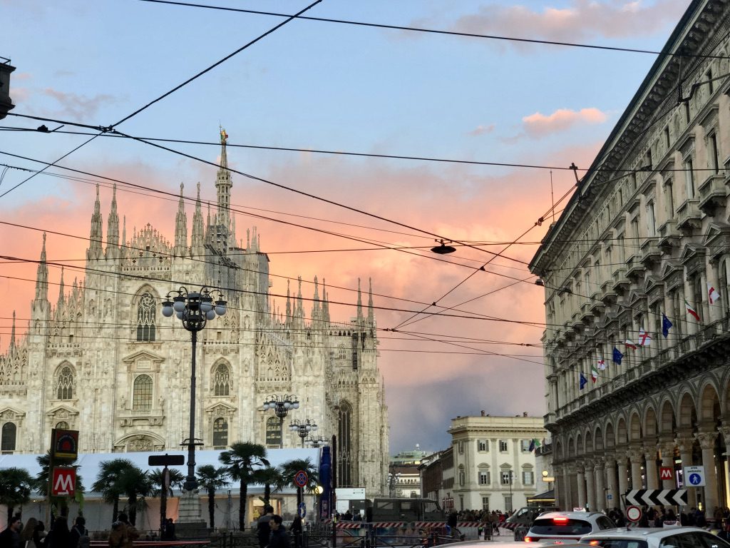A cathedral with a sky background and many cars